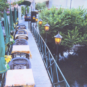 Restaurant tables on a bridge across the Sorgue